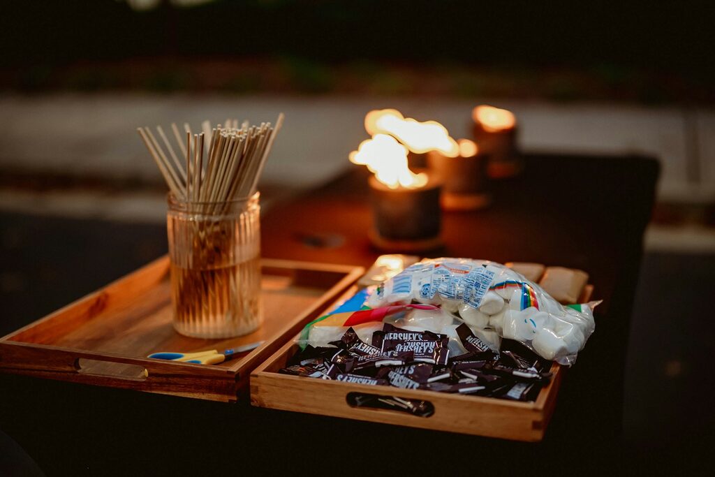 A wooden tray with a candle and a glass on it