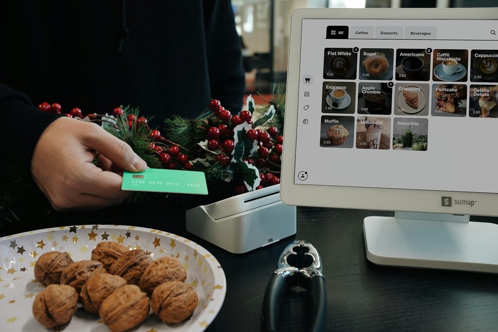 A person holding a green card next to a plate of cookies